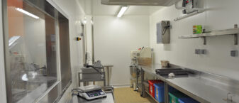Photo intérieure de la cuisine centrale de Rambouillet. Plans de travail en inox, sol carrelé et équipements de cuisine illustrent cette photo