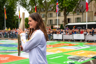Manon Chanclu, porteuse de la flamme, portant la flamme olympique sur le jeu de l'oie, place de la libération à Rambouillet. - Agrandir l'image 6 sur 11, fenêtre modale